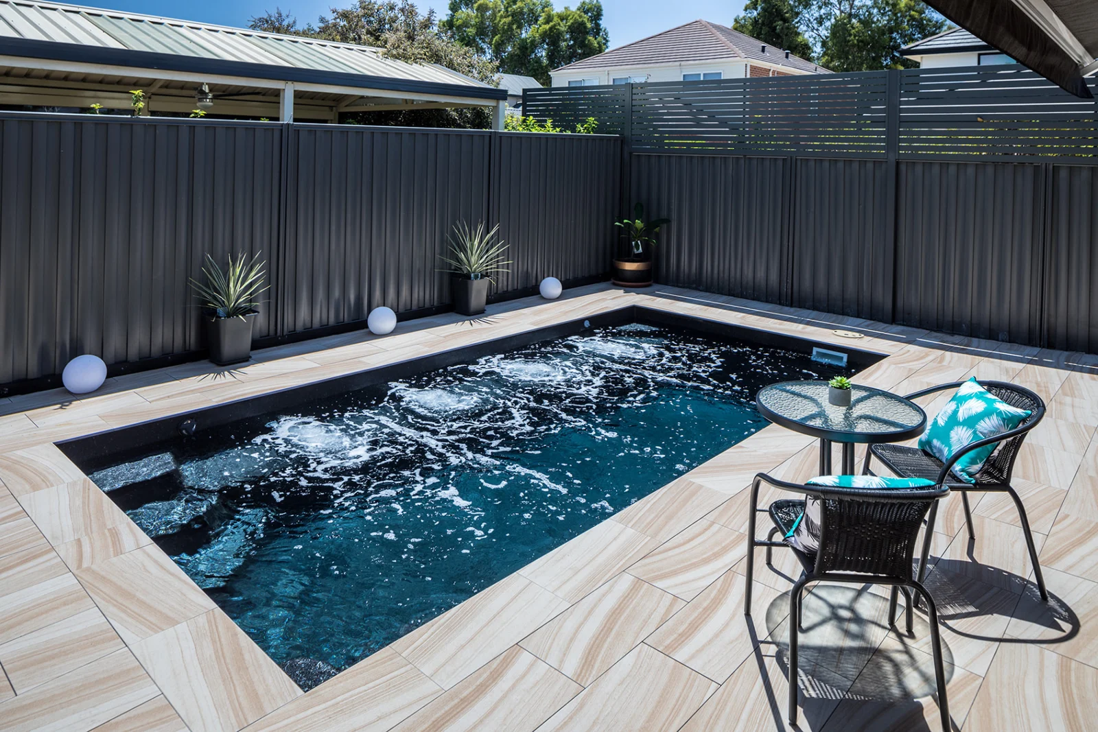 Completed Entertainer 7m fibreglass pool with tiled surrounds and poolside seating