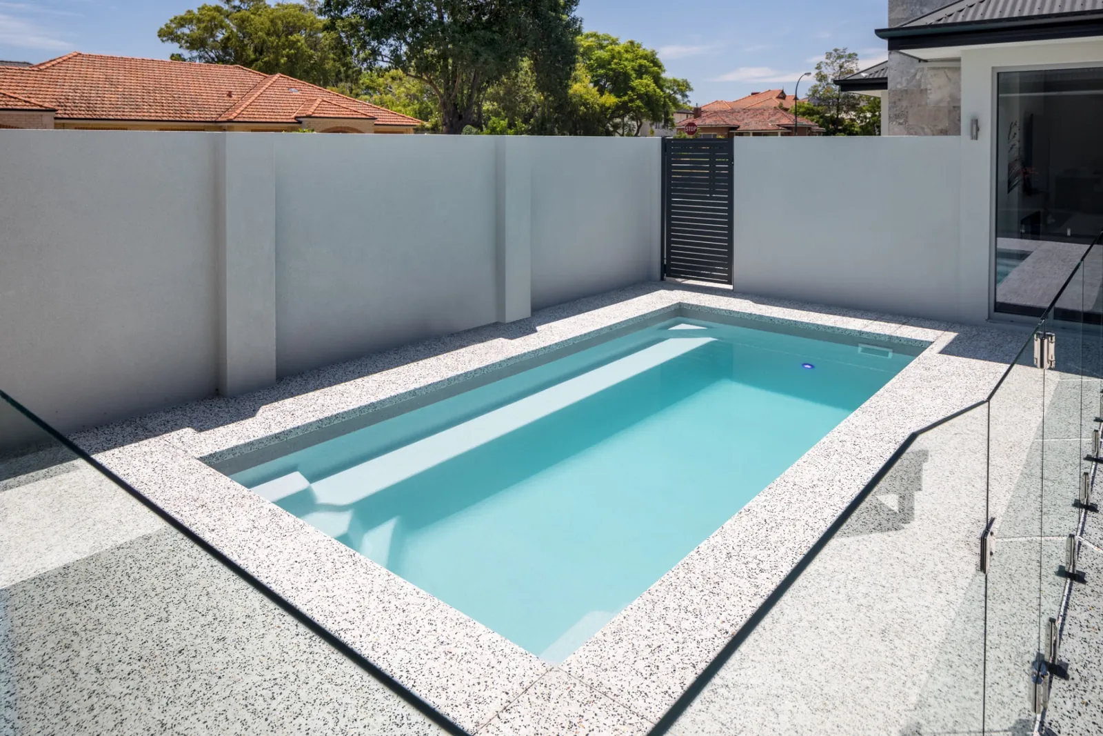 Freedom Pools Entertainer 7 fibreglass pool with frameless glass pool fence