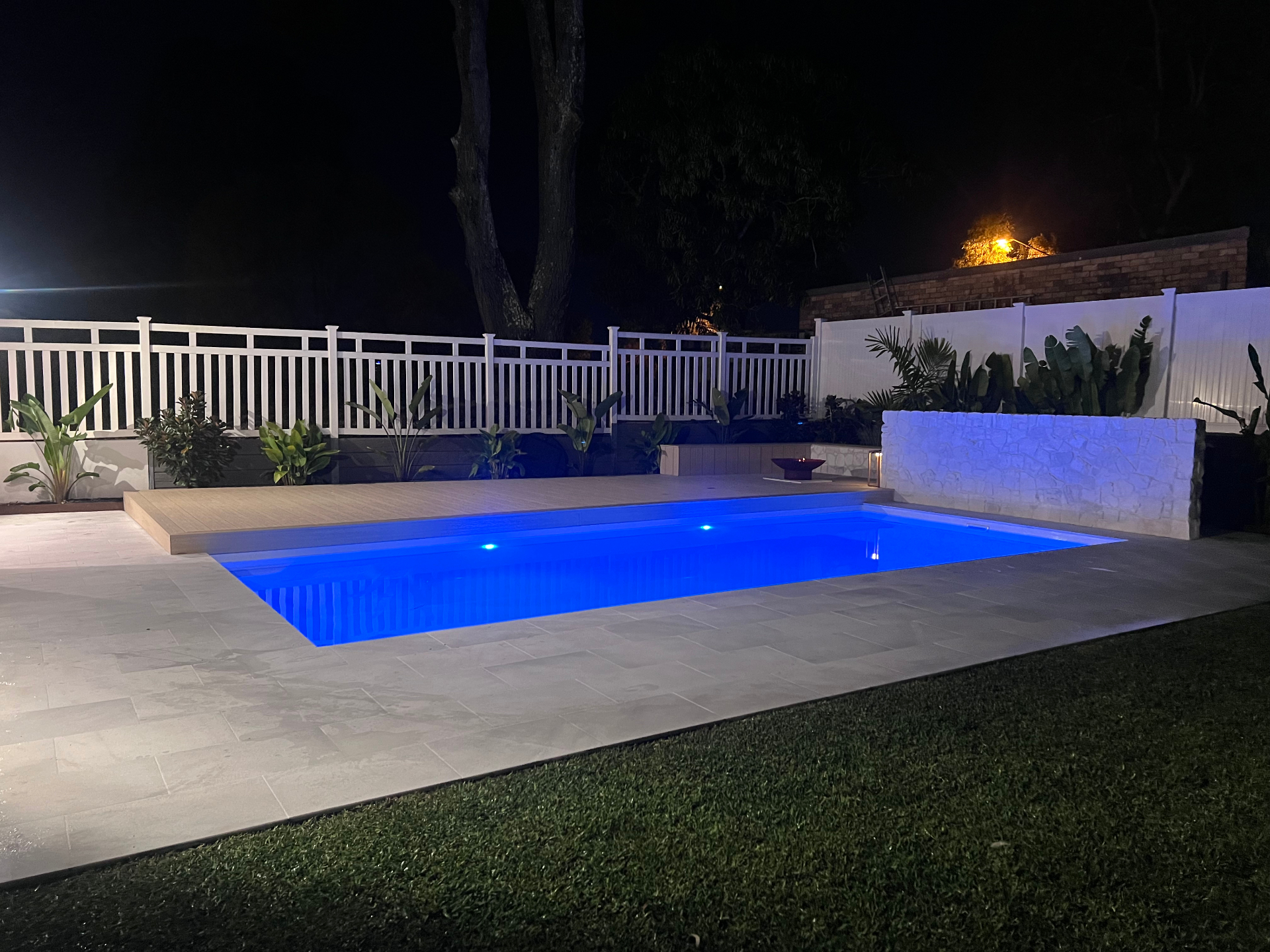 Night time pool with LED lighting and water feature