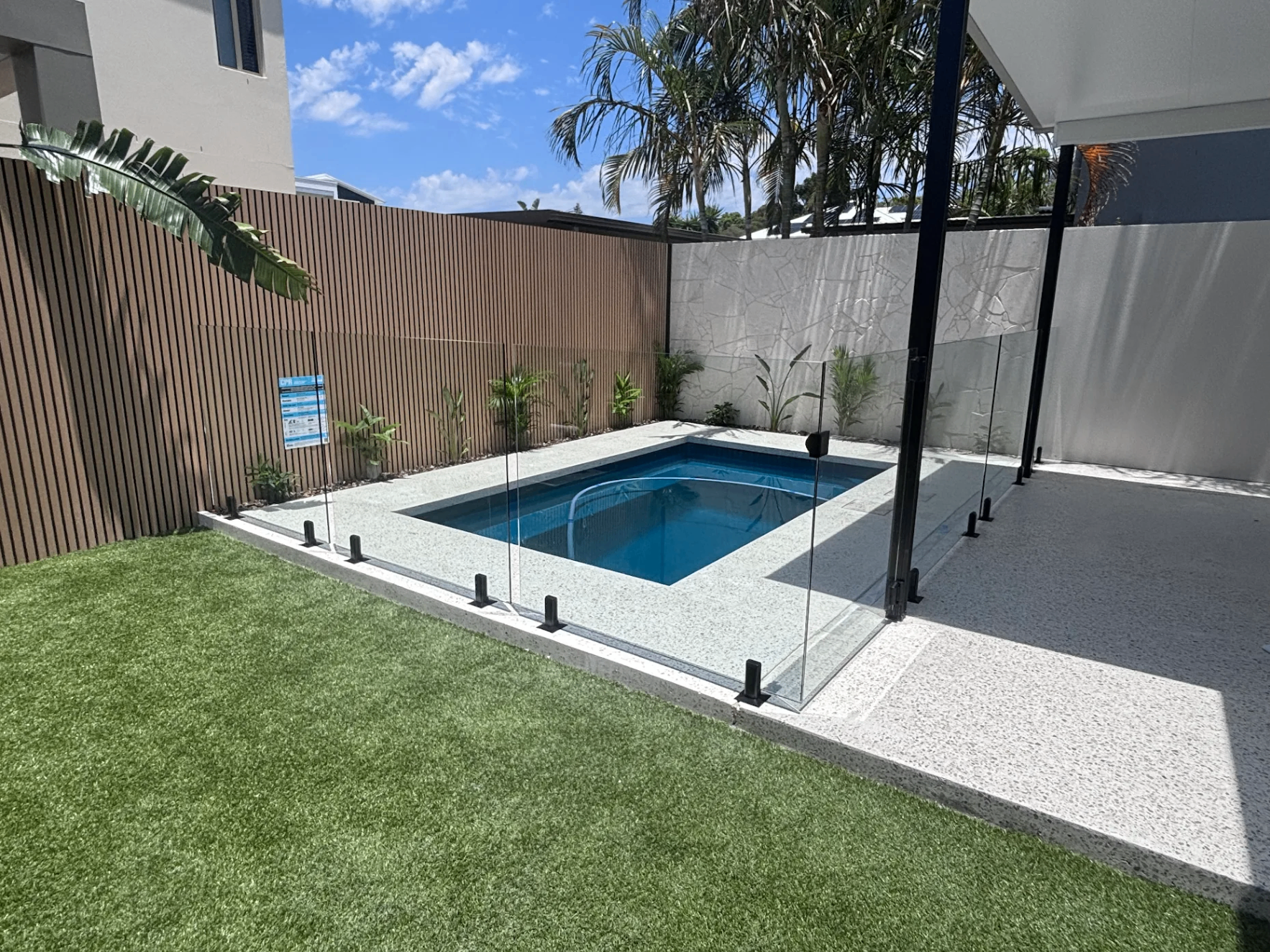Modern plunge pool with glass fencing and landscaping