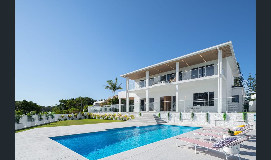 Contemporary lap pool with modern home daytime view