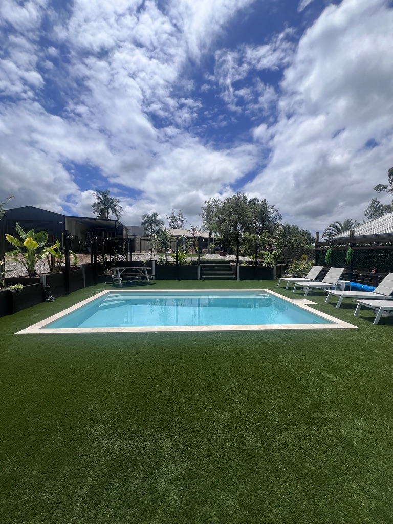 Family pool with artificial turf and outdoor lounges