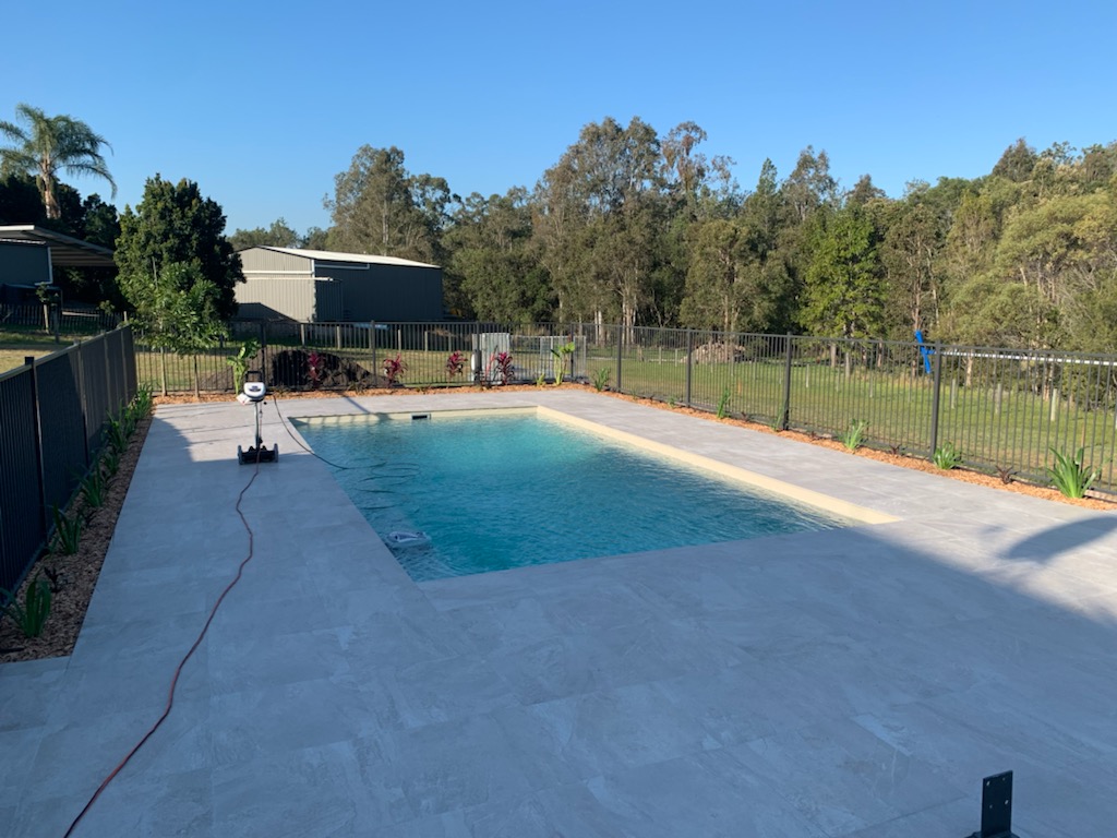 Fibreglass pool with tiled surround and safety fencing